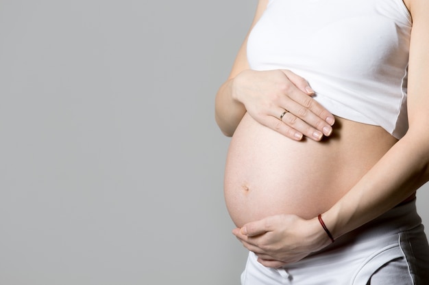 Free photo pregnant woman touching her belly